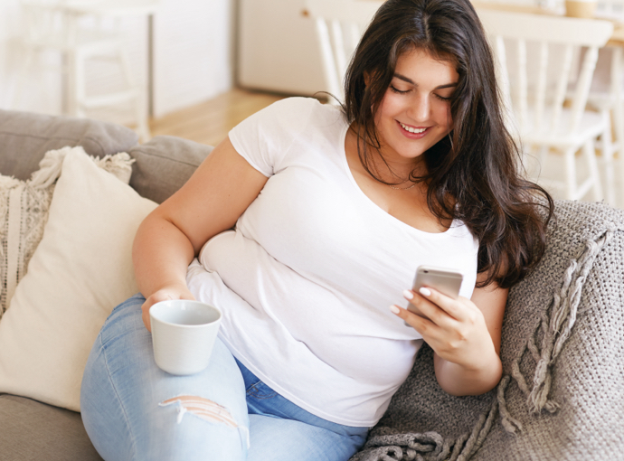 Woman sitting on couch looking at phone